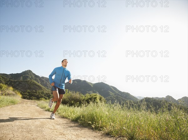 Mixed race man running on remote trail