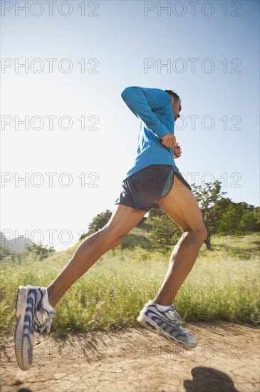 Mixed race man running on remote trail