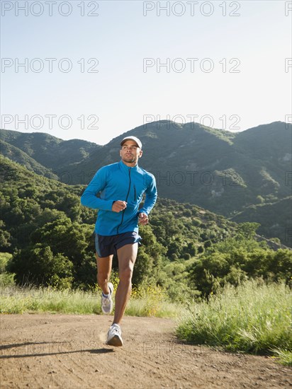 Mixed race man running on remote trail