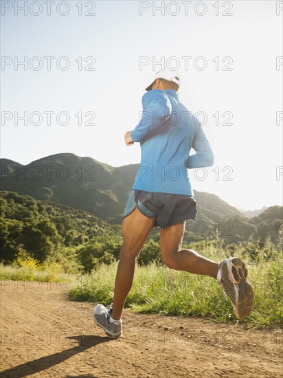 Mixed race man running on remote trail