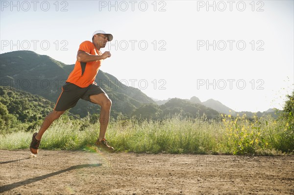 Mixed race man running on remote trail