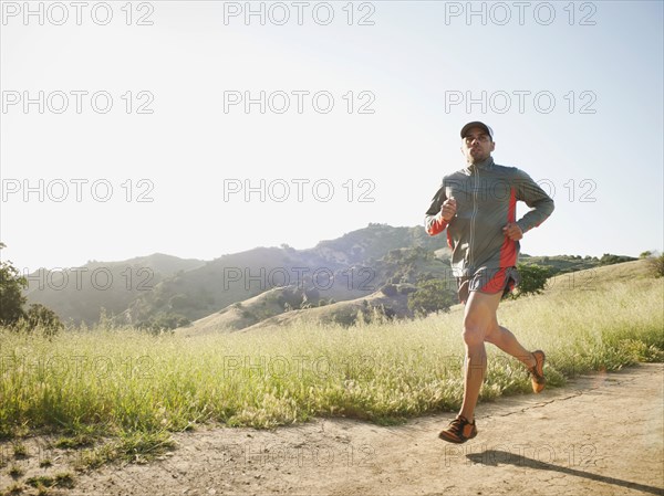 Mixed race man running on remote trail