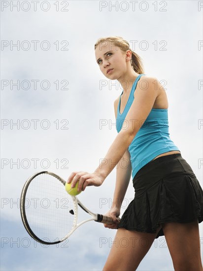 Caucasian woman serving tennis ball