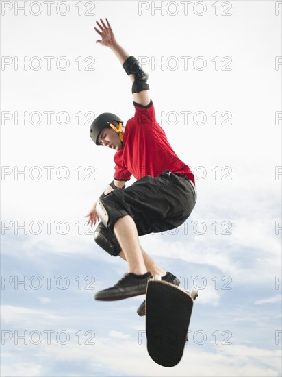 Caucasian man on skateboard in mid-air