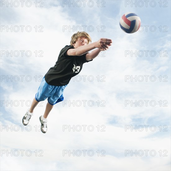 Caucasian teenager returning volleyball