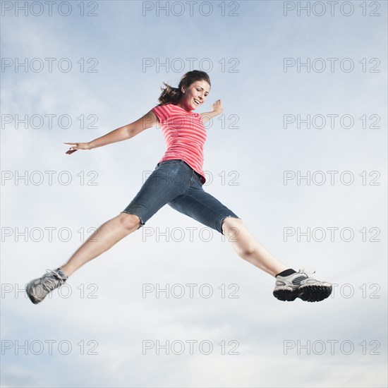 Caucasian teenager jumping in air