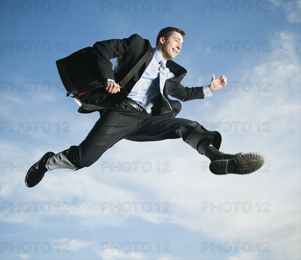 Caucasian businessman jumping in air