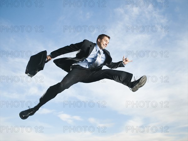 Caucasian businessman jumping in air