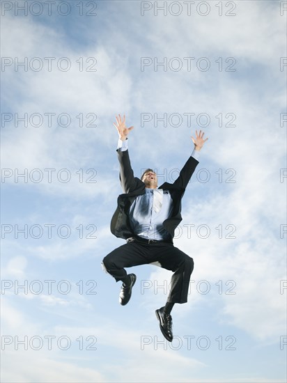 Caucasian businessman jumping in air