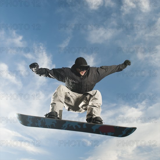 Caucasian man on snowboard in mid-air