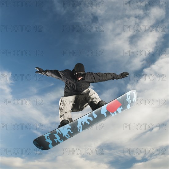 Caucasian man on snowboard in mid-air