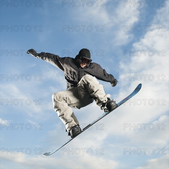 Caucasian man on snowboard in mid-air