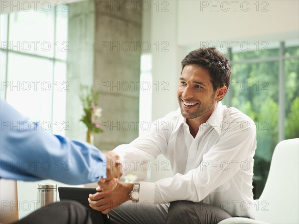 Businessmen shaking hands in lobby