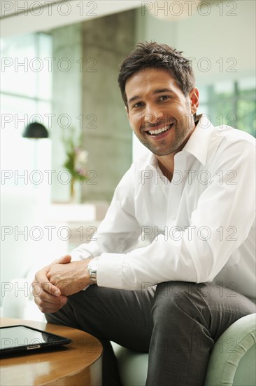 Smiling mixed race businessman in lobby