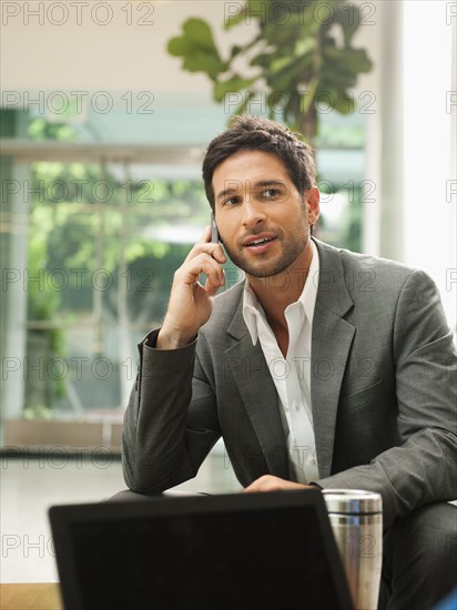 Mixed race businessman talking on cell phone