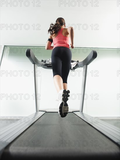 Mixed race woman running on treadmill