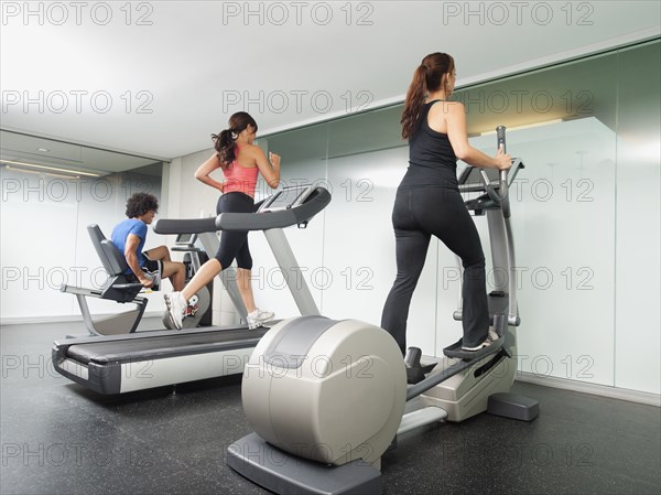 People using gym exercise equipment