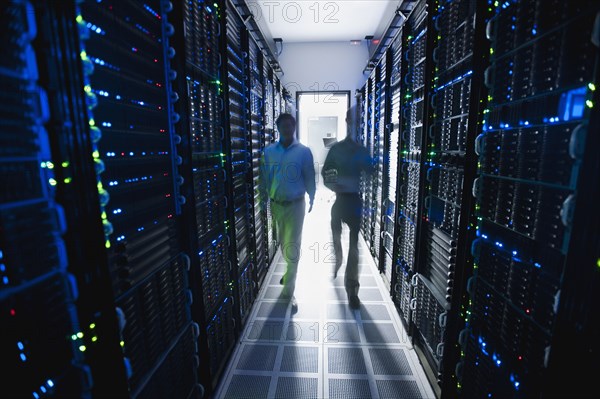 Businessmen walking in server room