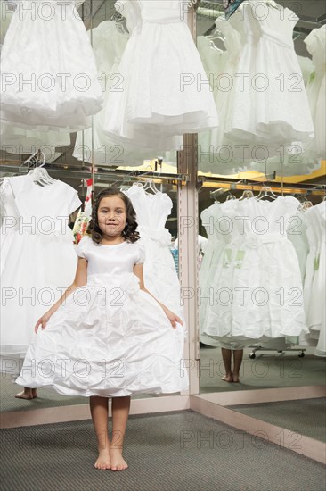 Mixed race girl trying on white dress