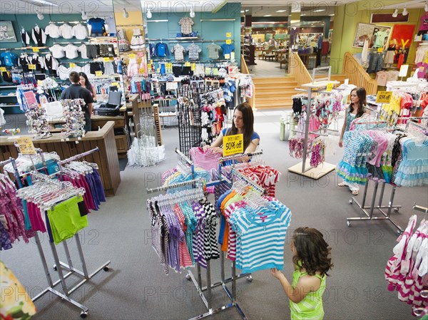 Mixed race mother and daughter shopping for children's clothing