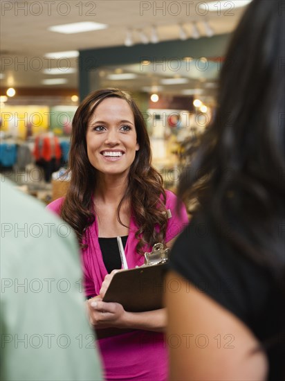 Woman talking to customers in store