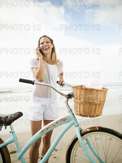 Caucasian woman using cell phone on beach