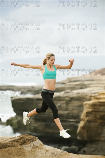 Caucasian woman running on beach