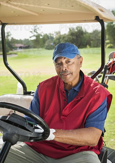 Black man driving golf cart