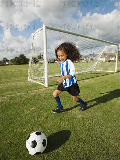 Mixed race girl playing soccer