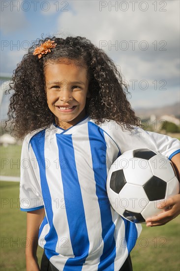 Mixed race girl holding soccer ball