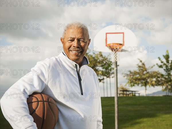 Black man carrying basketball