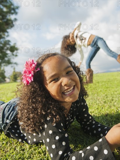 Mixed race girl laying in grass