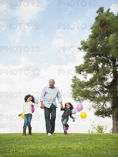Man walking with granddaughters in park