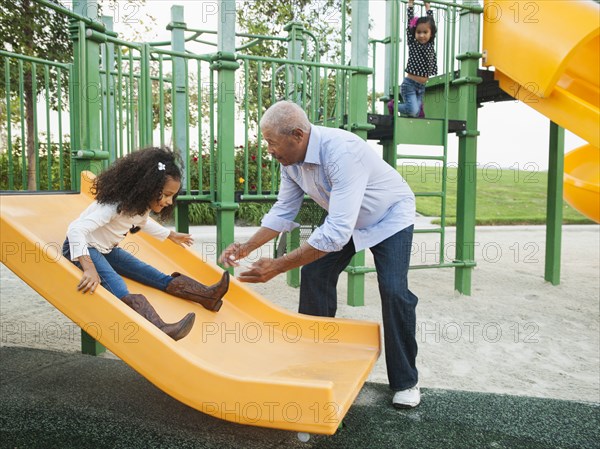 Man playing with granddaughter at park