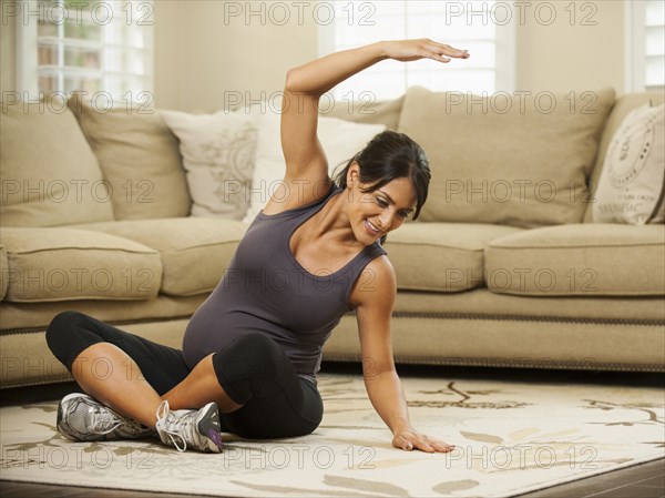 Pregnant Hispanic woman stretching