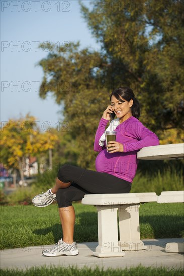 Pregnant Hispanic woman talking on cell phone