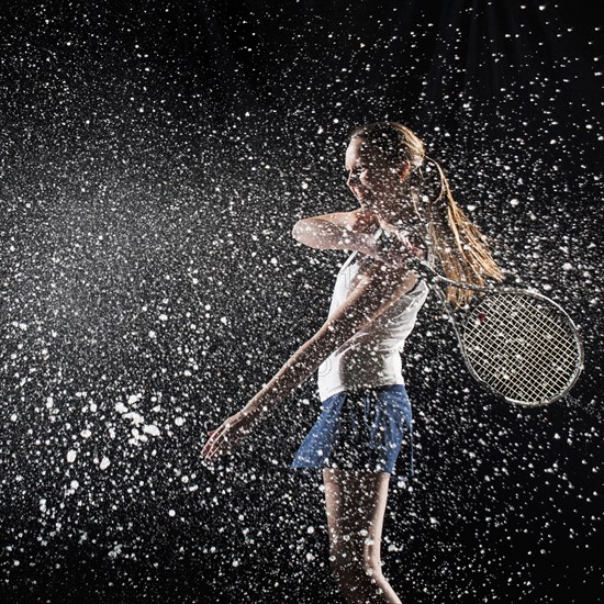 Caucasian tennis player splashing in water