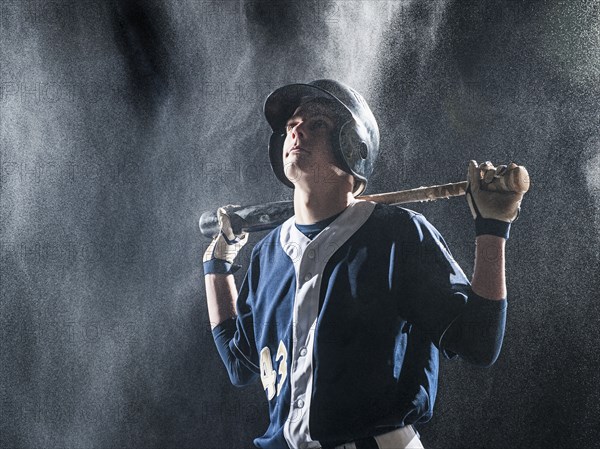 Caucasian baseball player standing in rain