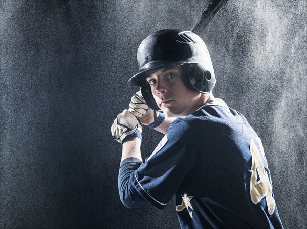 Caucasian baseball player standing in rain