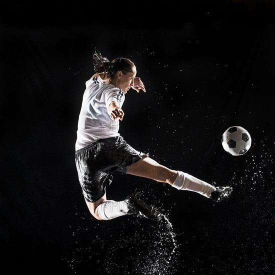 Hispanic soccer player splashing in water