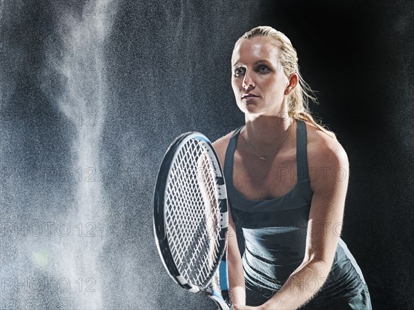 Caucasian tennis player standing in rain