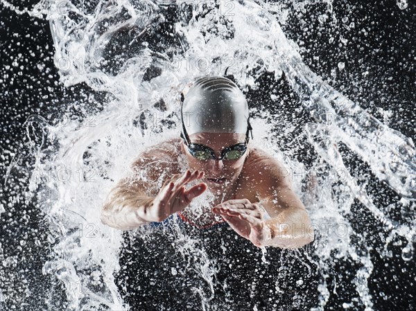 Caucasian swimmer splashing in water