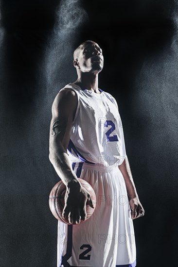 African American basketball player standing under lights