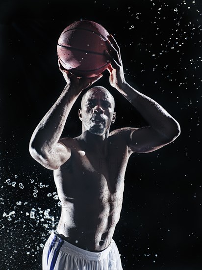 African American basketball player splashing in water