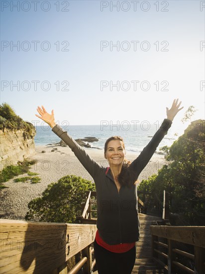 Mixed race woman climbing steps on beach