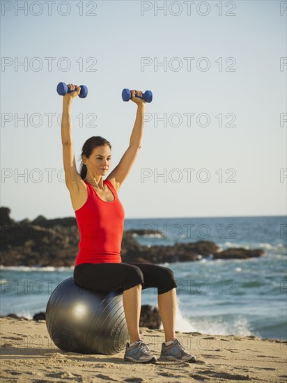 Mixed race woman exercising on beach