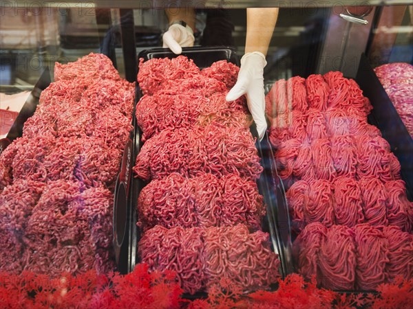 Hispanic butcher at meat counter of grocery store