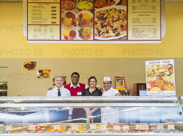 Business people and chefs behind restaurant counter