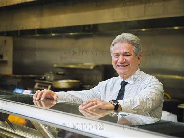 Hispanic businessman smiling in kitchen