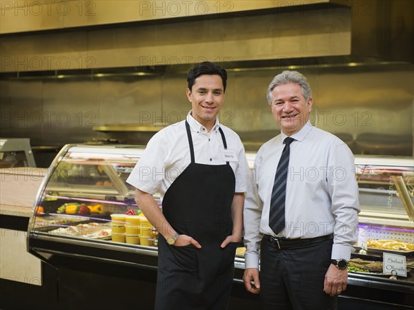 Hispanic businessman and worker in kitchen